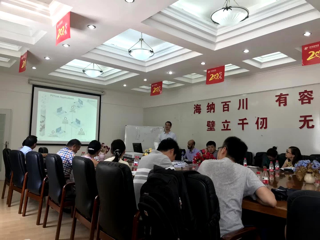 新疆油田站交流现场，投影屏幕显示 PVTsim Applications 页面