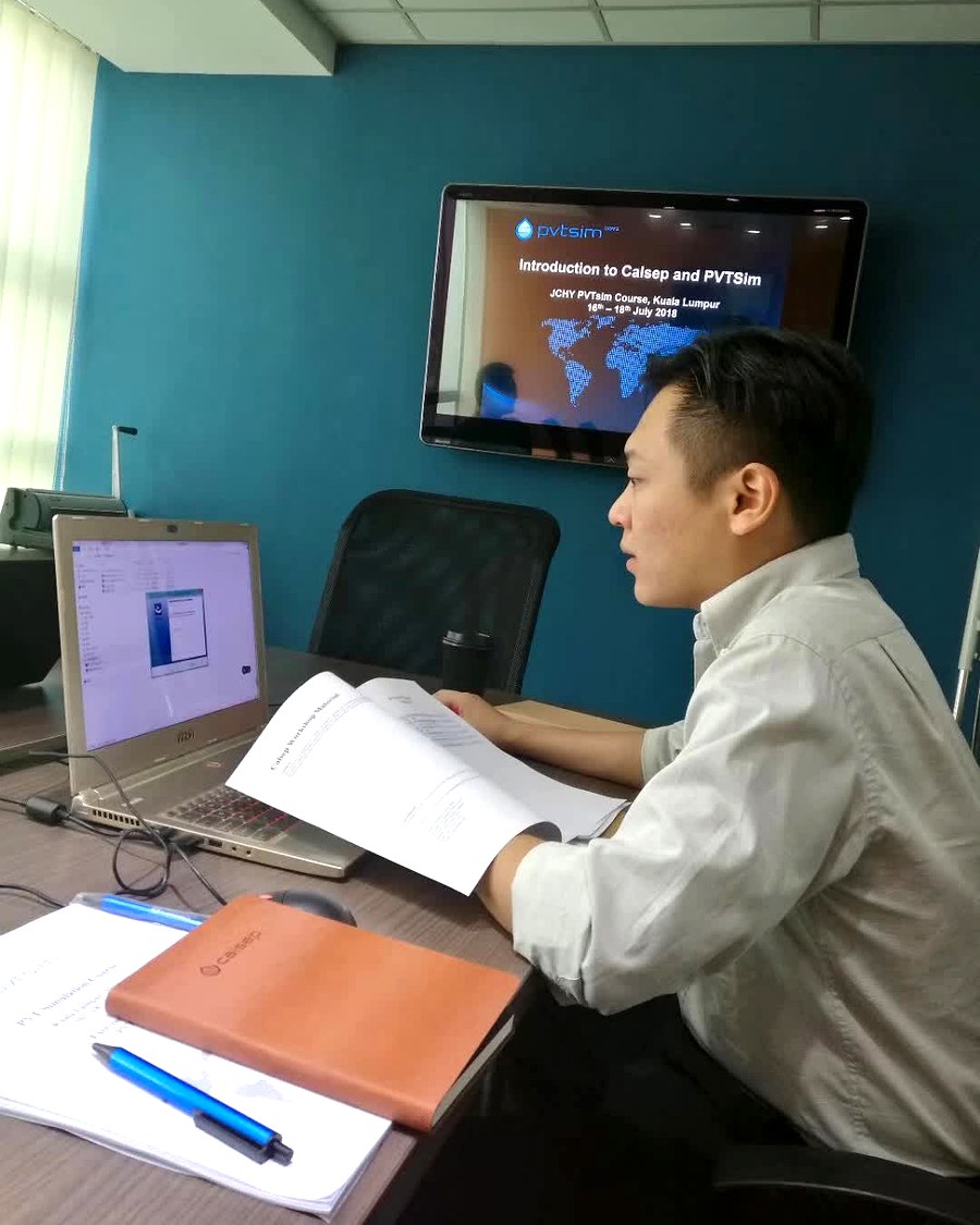 桌面上摊开的 PVTsim 课程讲义、练习册与印有 CALSEP 标识的笔记本