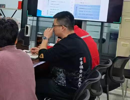 与会人员围绕长桌听取软件功能模块讲解并记录